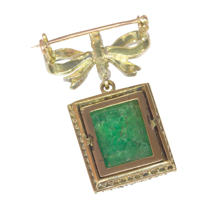 Antique Victorian diamond bow brooch with large emerald pendant hanging underneath by Artista Desconhecido