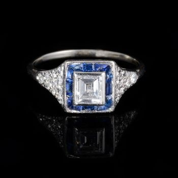 Baguette cut diamond with sapphire surround ring by Artista Desconocido