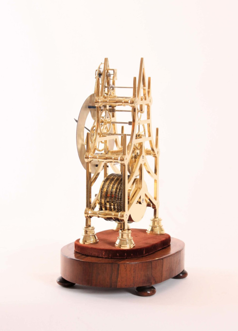 A small English brass skeleton clock with balance wheel, circa 1840 by Onbekende Kunstenaar