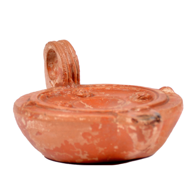  A Roman terracotta red slip ware oil lamp with theatre masks by Artiste Inconnu