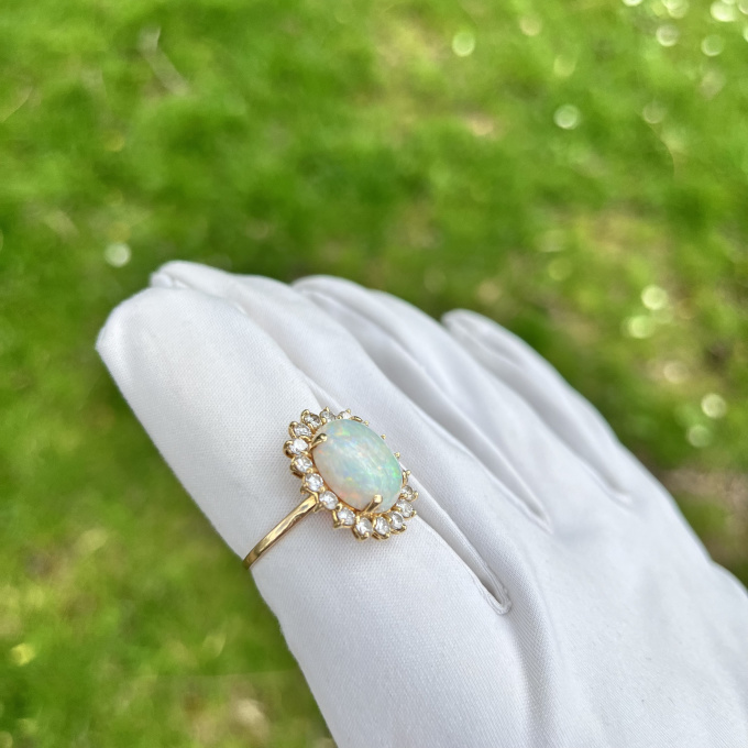 Yellow gold ring with white opal and diamond halo by Artista Sconosciuto