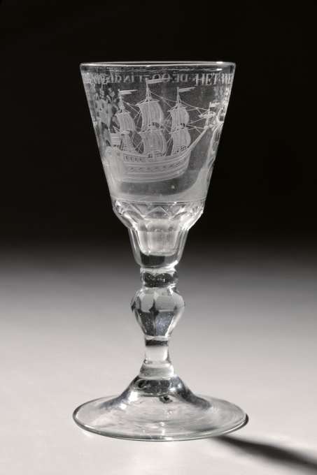 A GLASS WITH THE ENGRAVING OF AN EAST-INDIAMAN AND WITH TEXT "HET WEL VAAREN VAN DE OOSTINDISCHE COMPAGNIE" by Onbekende Kunstenaar