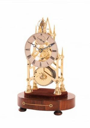 A small English brass skeleton clock with balance wheel, circa 1840 by Artiste Inconnu