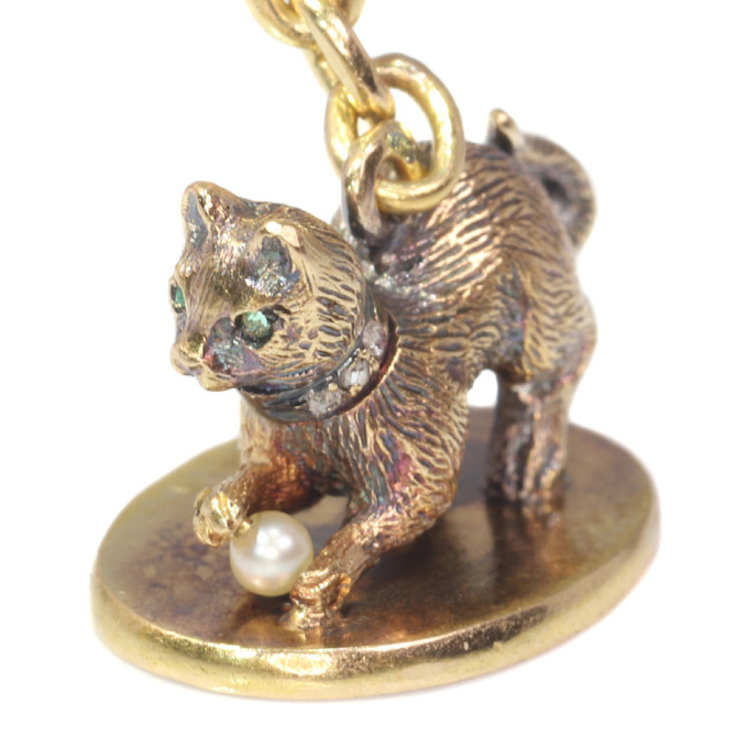 Antique gold kitten with diamond collar playing with little pearl on seal by Onbekende Kunstenaar